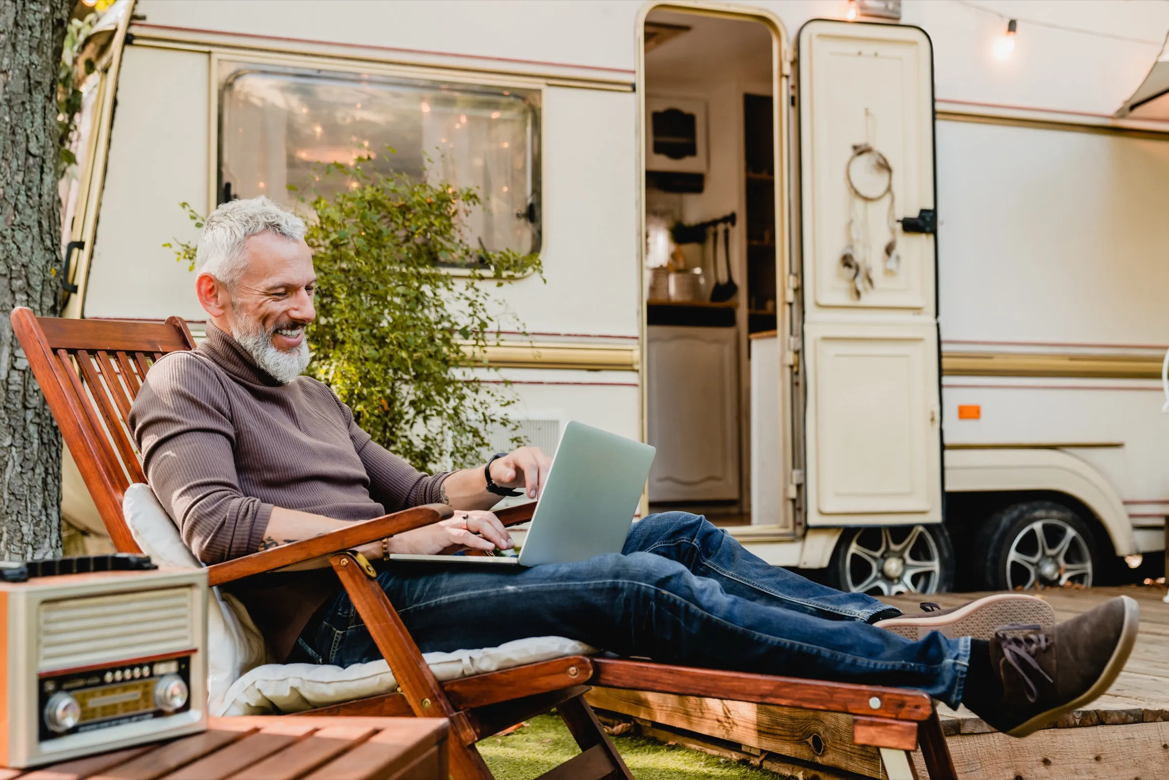 Someone working on a laptop outdoors, at the edge of their Wi-Fi.